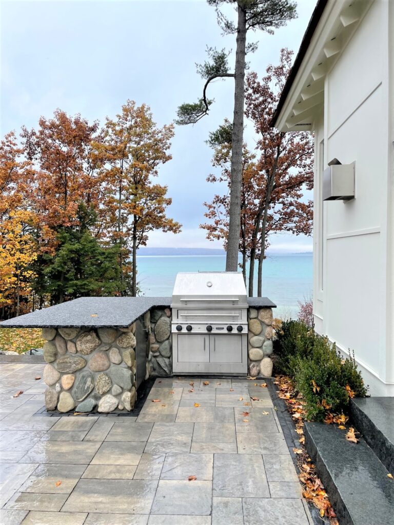 Outdoor kitchen grill and countertop with a beautiful lakeside view
