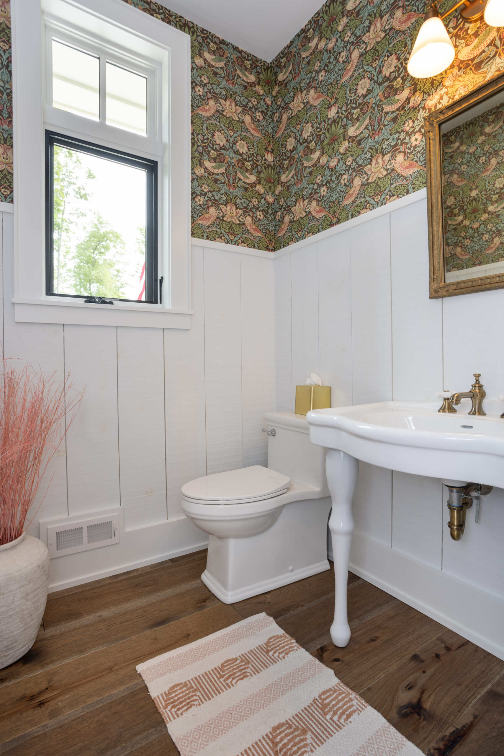 Charming powder bathroom with vintage wallpaper and pedestal sink.