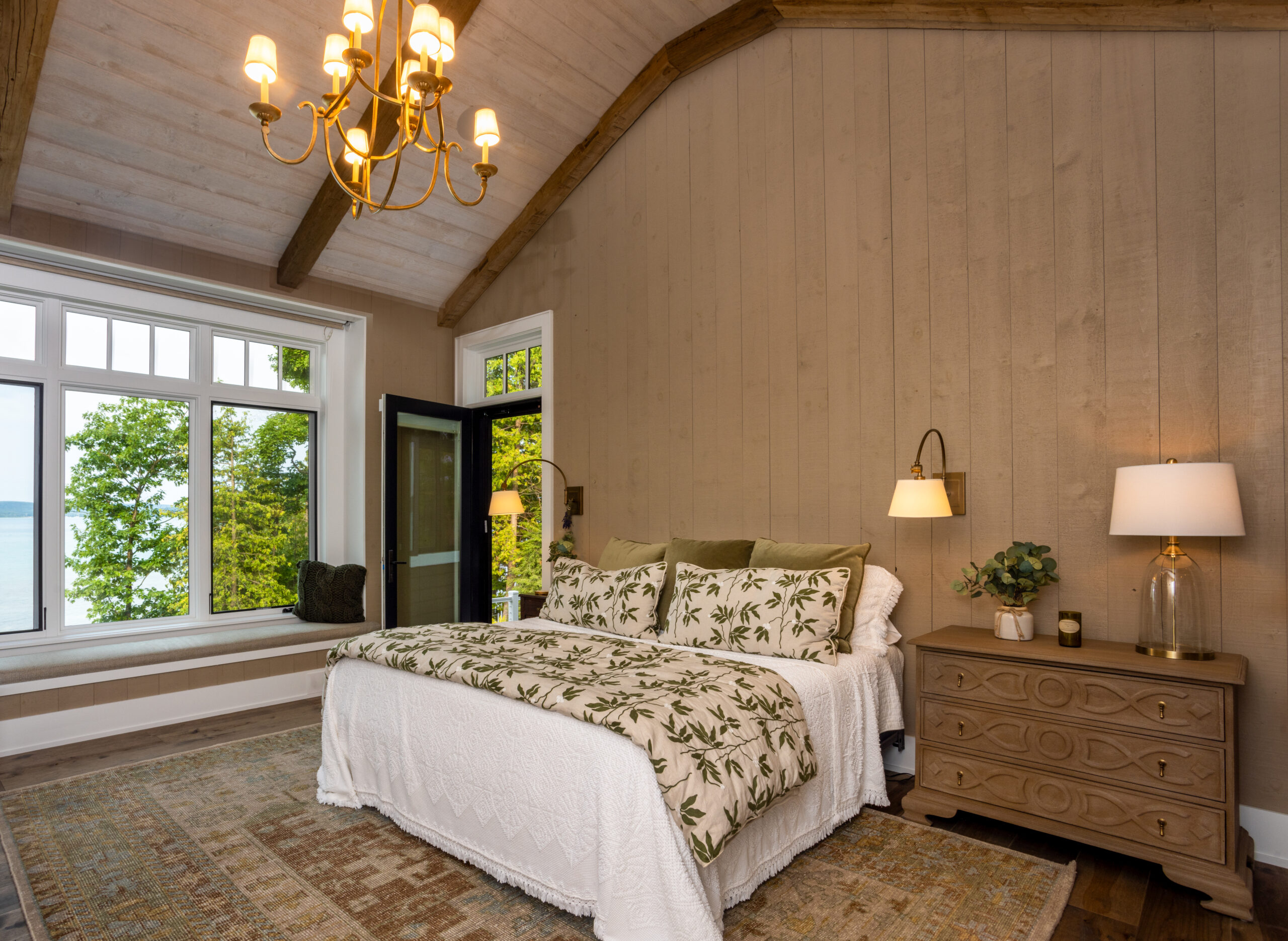 Cozy bedroom with lake view, vaulted ceiling, and rustic wood accents.
