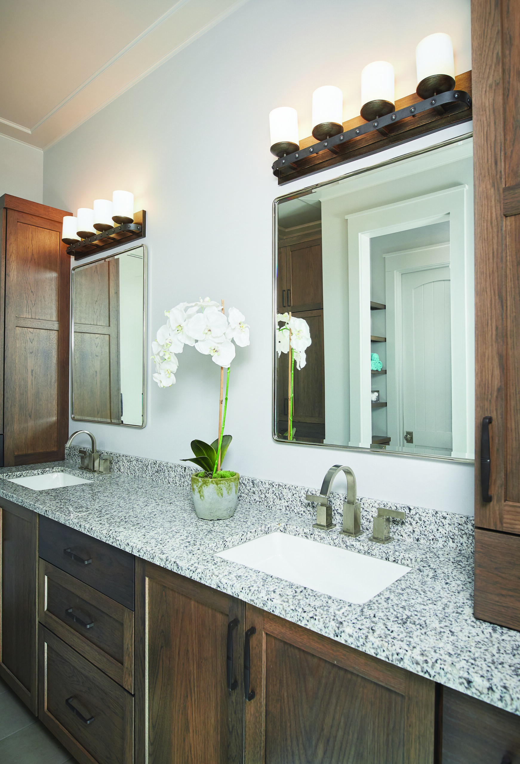 Double vanity bathroom with wood cabinetry and granite countertops in Glen Arbor home