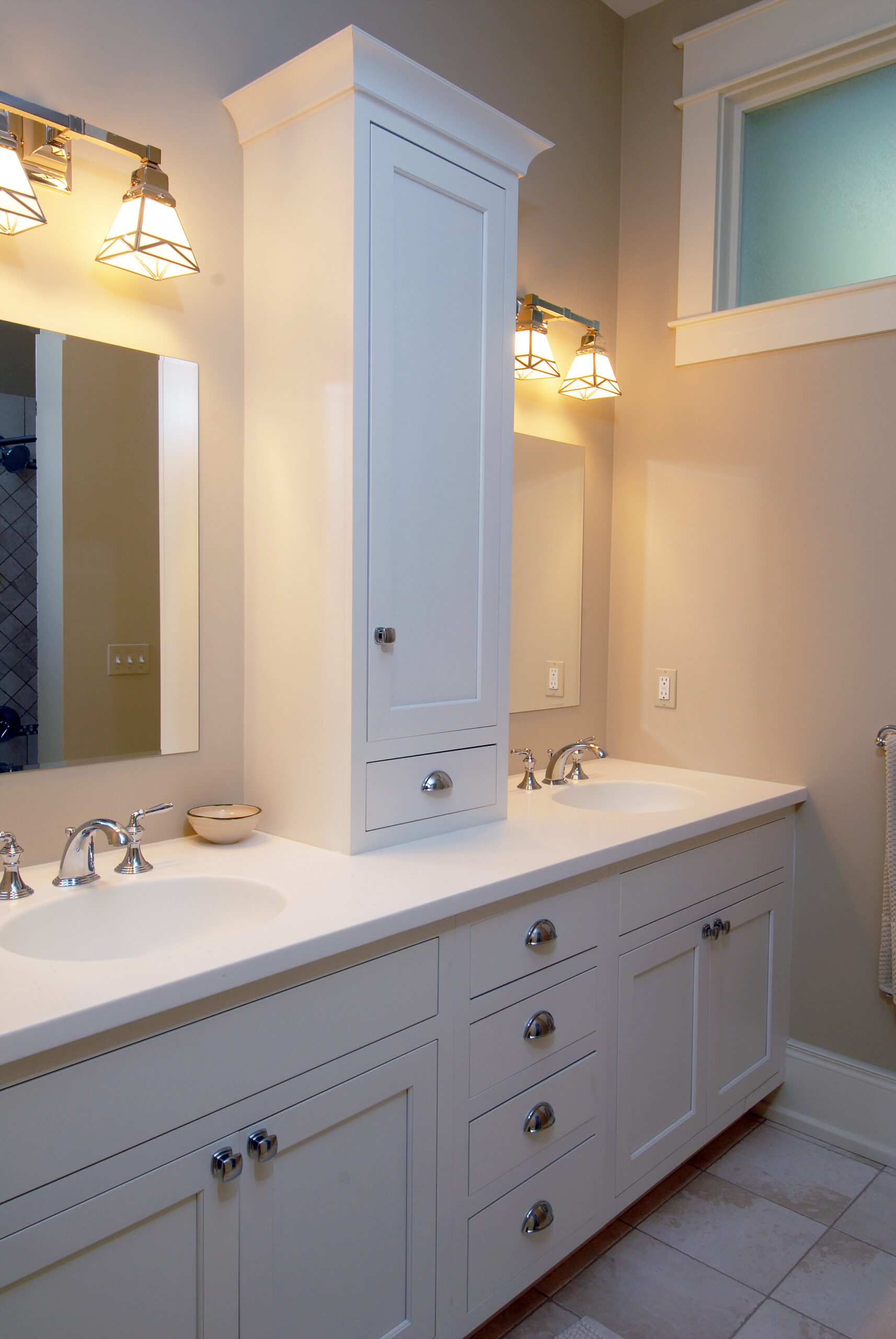 White double-sink bathroom vanity with built-in linen cabinet, quartz countertop, and modern wall sconces