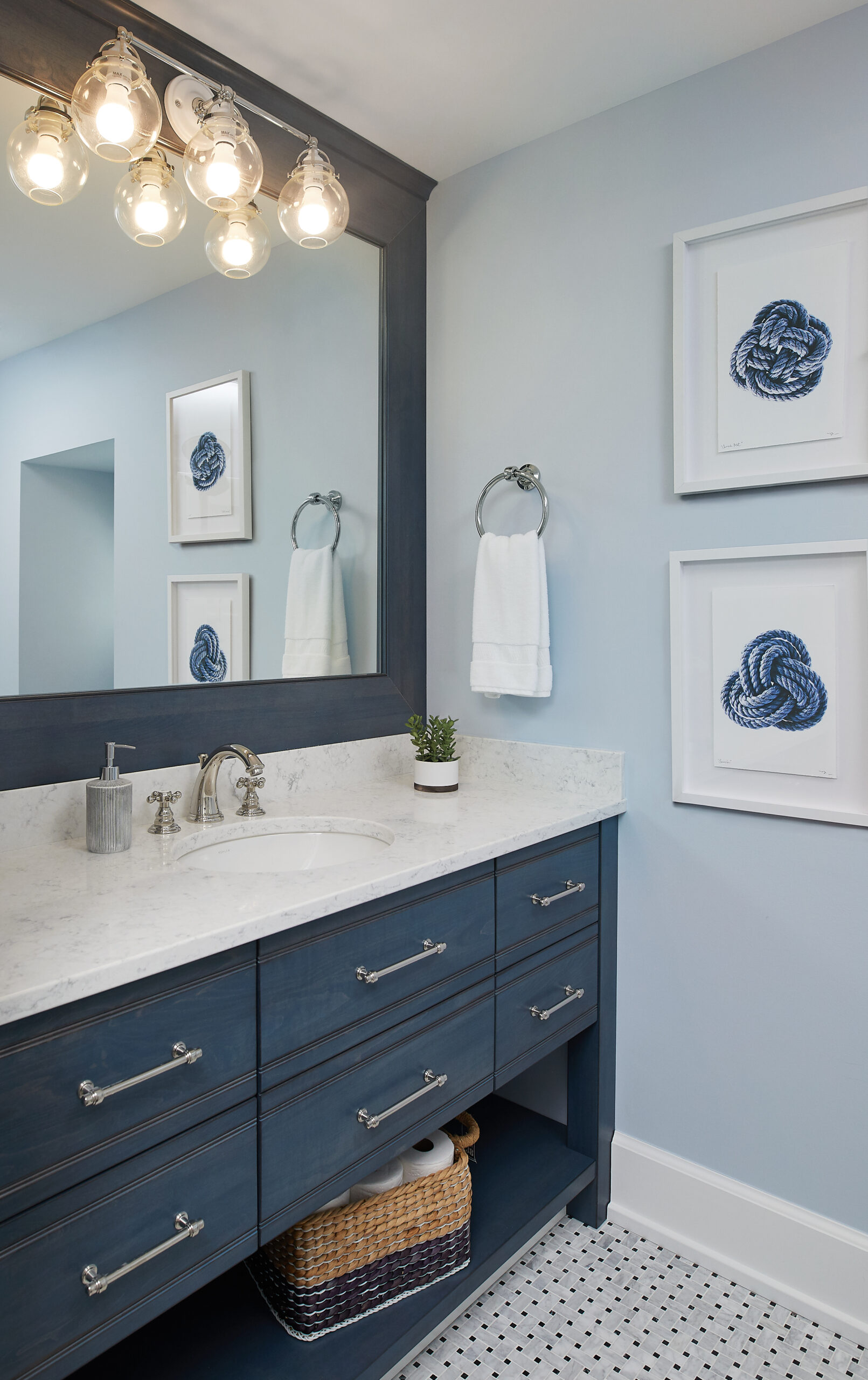 Navy blue guest bathroom vanity with marble countertop and framed mirror