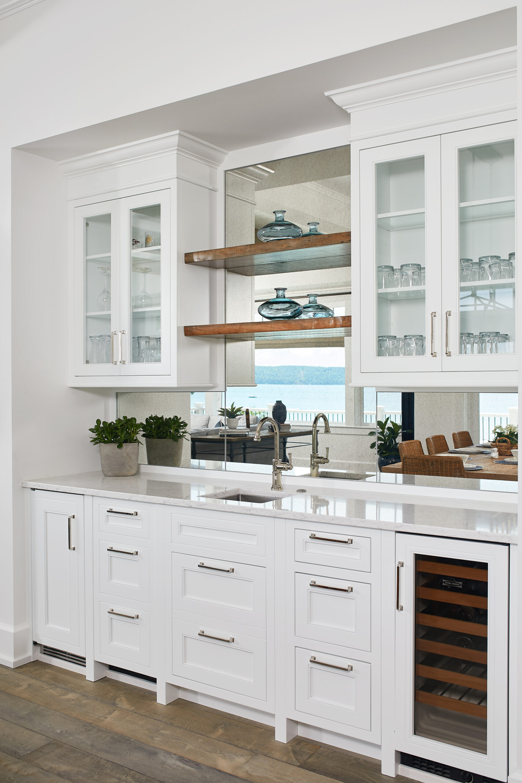 custom cabinetry - White built-in wet bar with glass-front cabinets and lake view