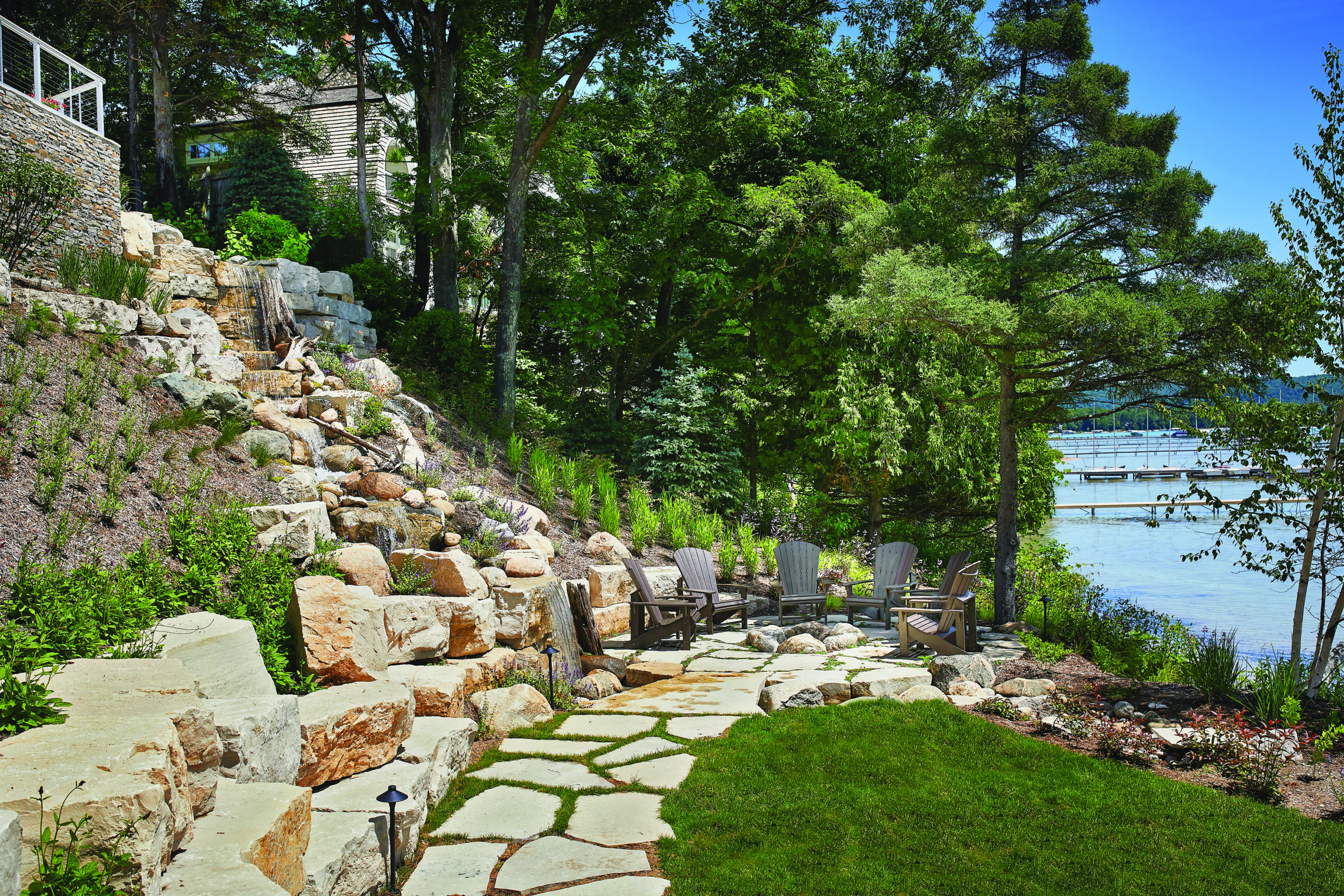 Lakeside stone water feature and seating area with natural landscaping