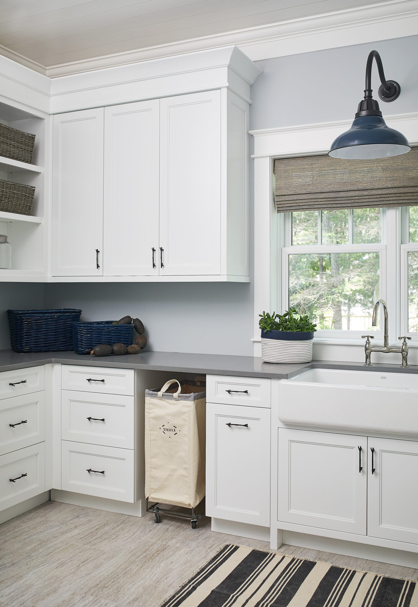 Bright white laundry room with farmhouse sink and custom cabinetry