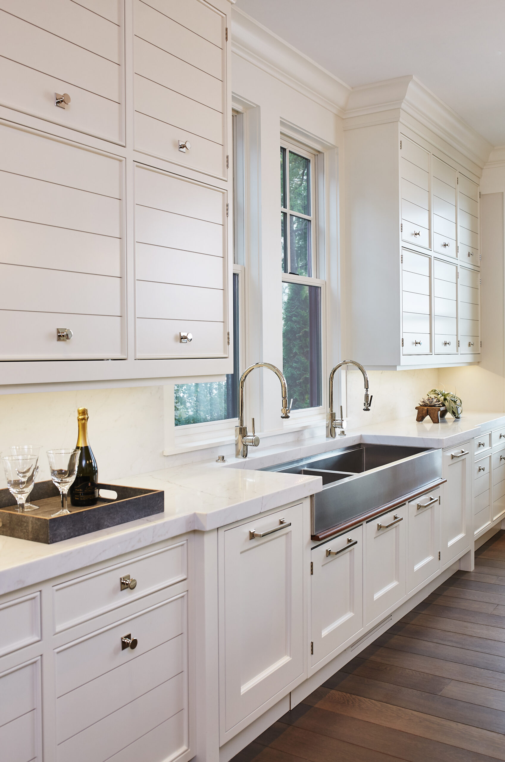 Custom white kitchen cabinetry with farmhouse sink and quartz countertops