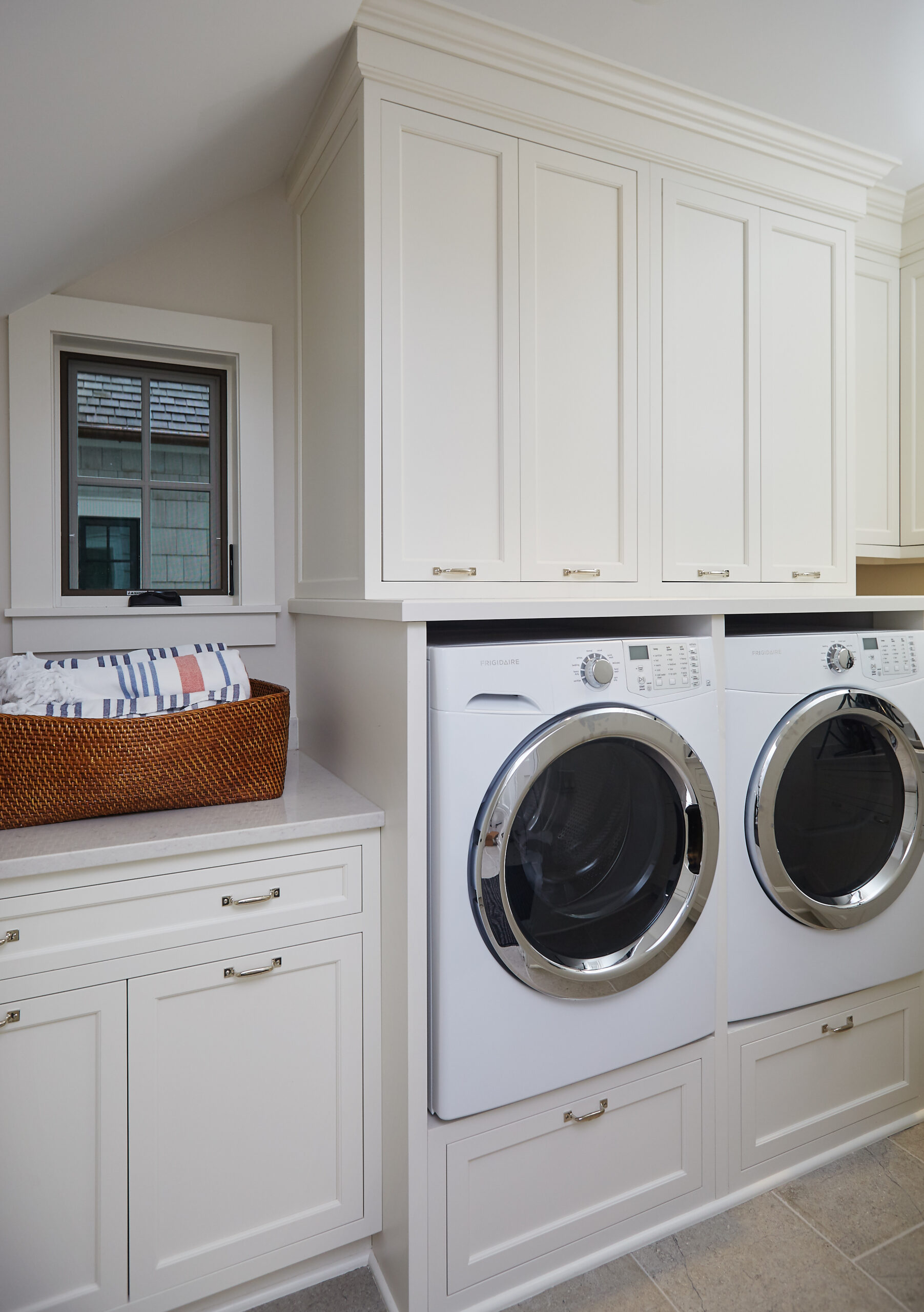Custom laundry room with built-in cabinetry and front-loading washer and dryer