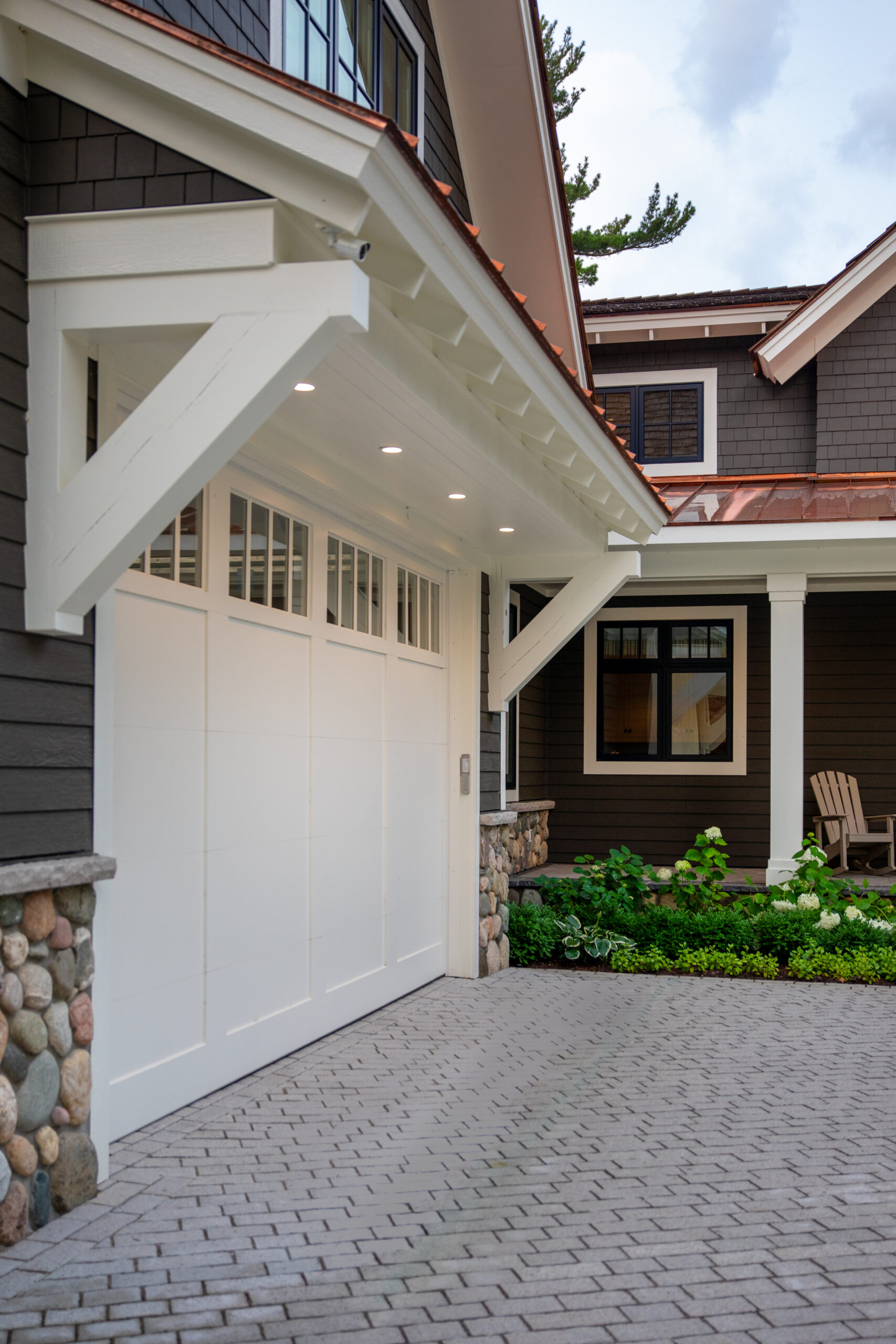 Garage with white door, corbels, and copper roof detail