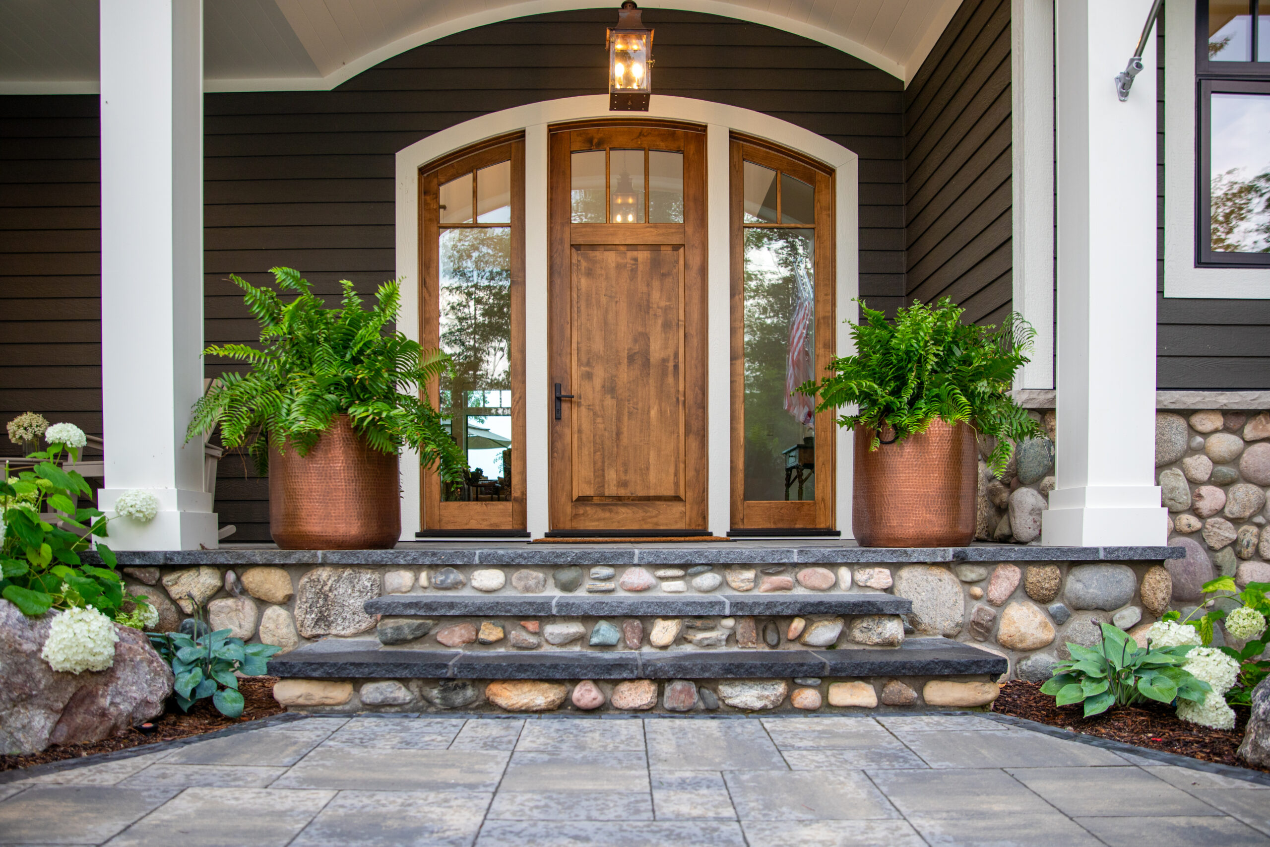 Front porch with wood door and copper planters