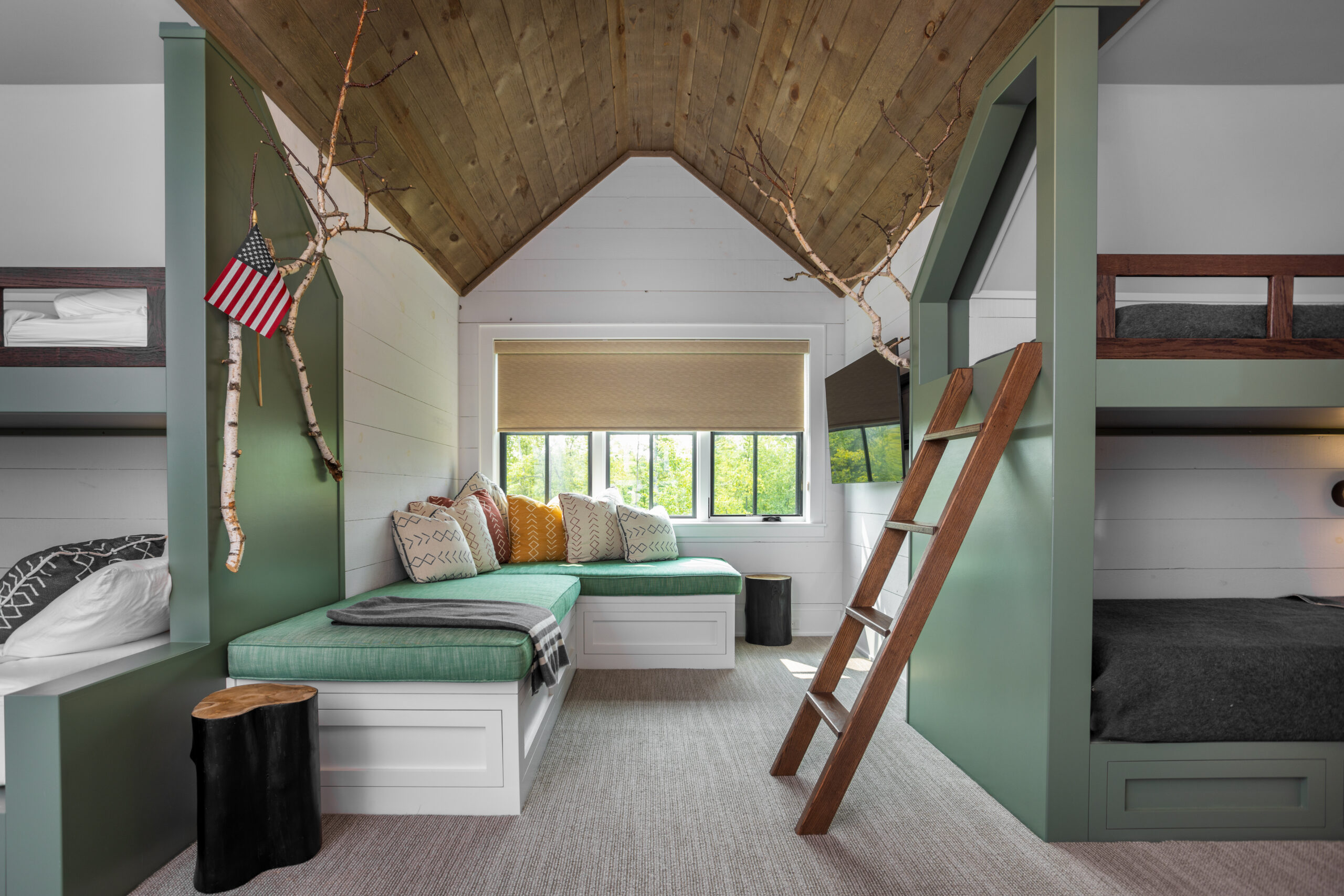 Built-in bunk room with green accents and wood ceiling