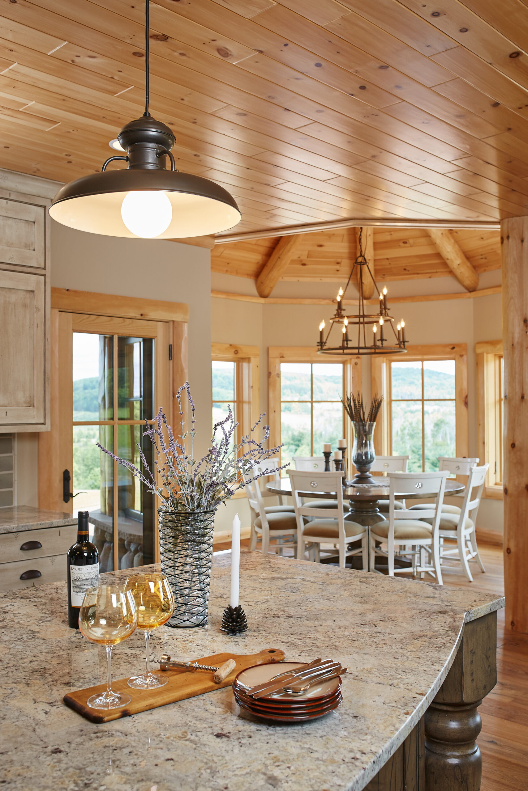 Rustic kitchen island with stone countertop and wood ceiling