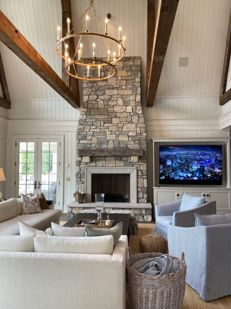 Vaulted living room with stone fireplace and circular chandelier