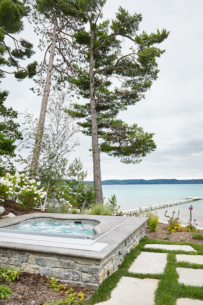 Lakeside hot tub with dock and pine trees