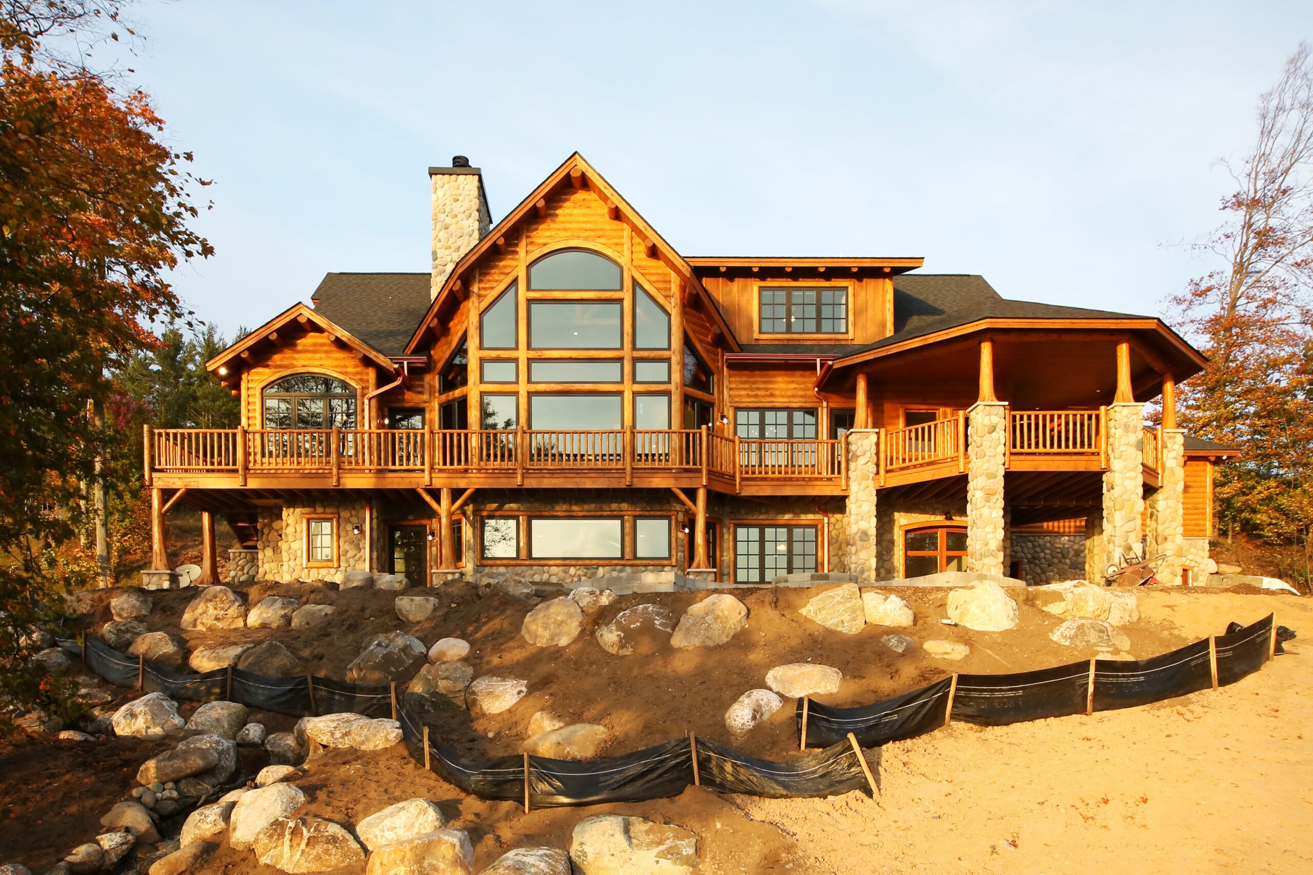 Lake Charlevoix custom home exterior with arched windows and elevated deck