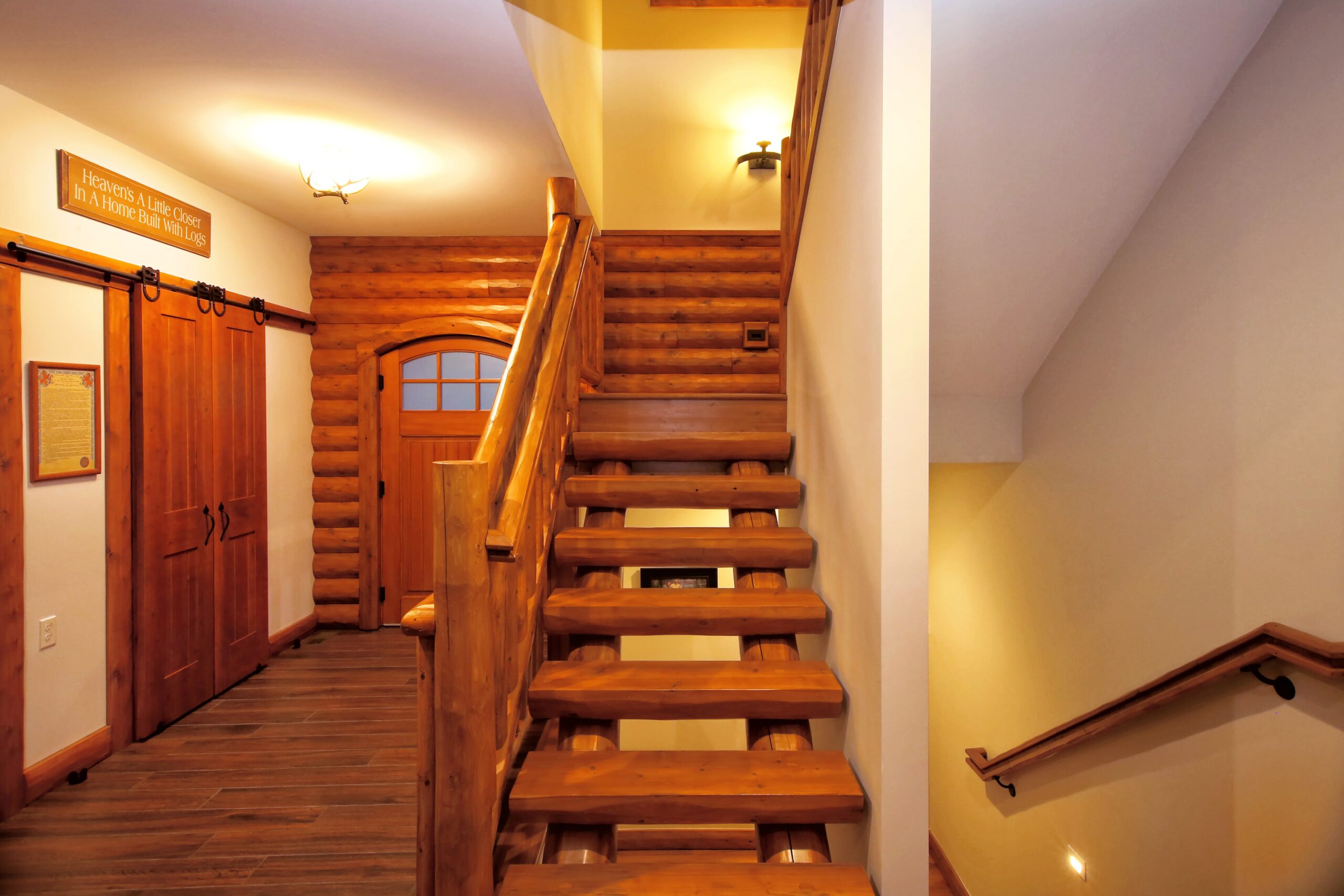 Custom log staircase with natural wood finishes and sliding barn doors.