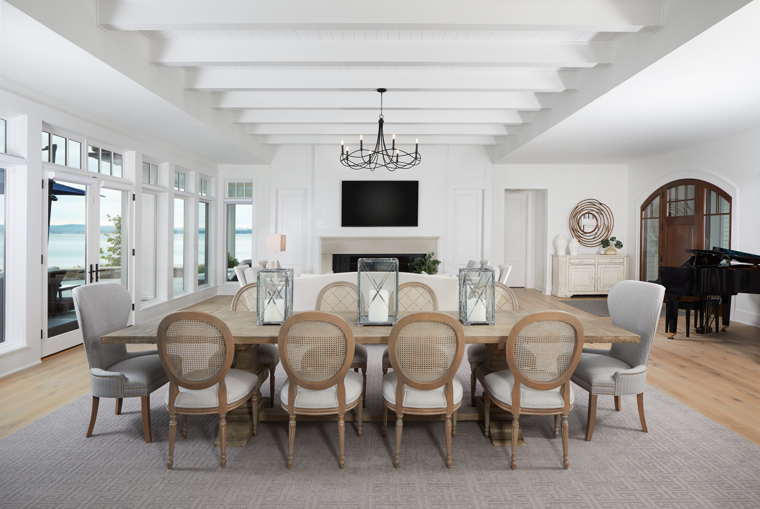 Bright open-concept dining and living room with lake views and elegant coastal décor.