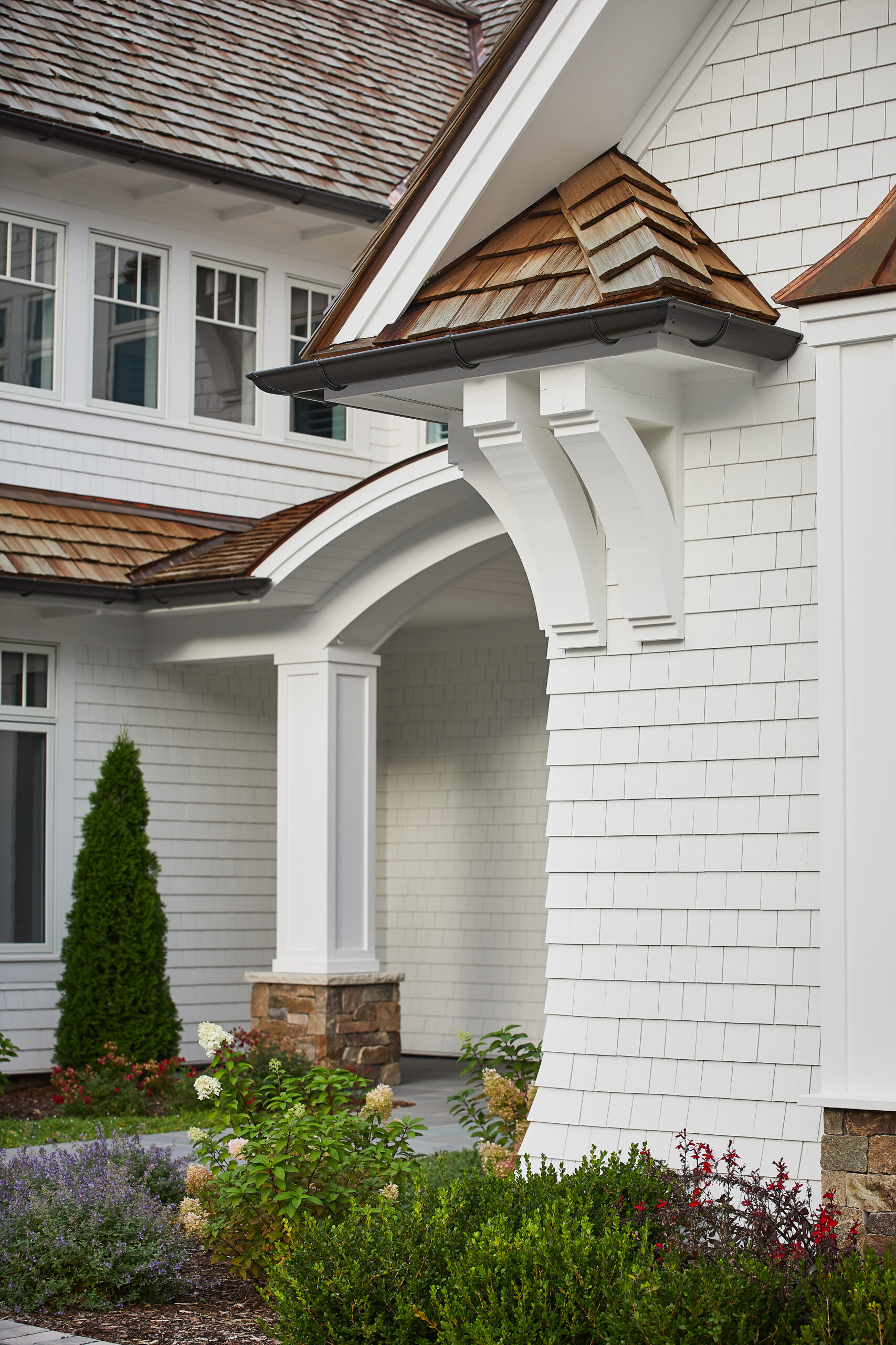 Close-up of white shingle siding and architectural brackets on a luxury home.