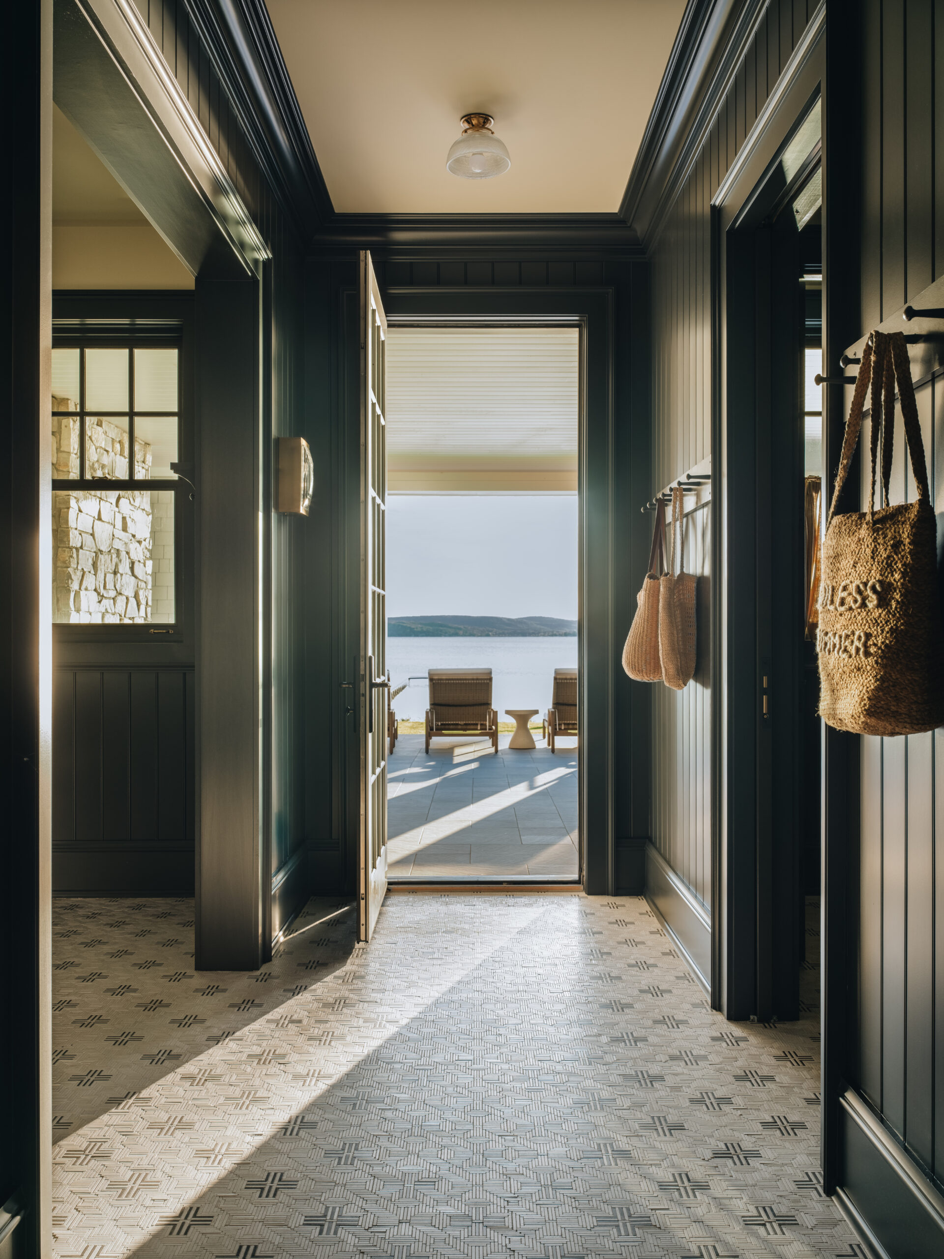 Hallway with lake view in Glen Lake custom home featuring patterned tile and French doors to patio