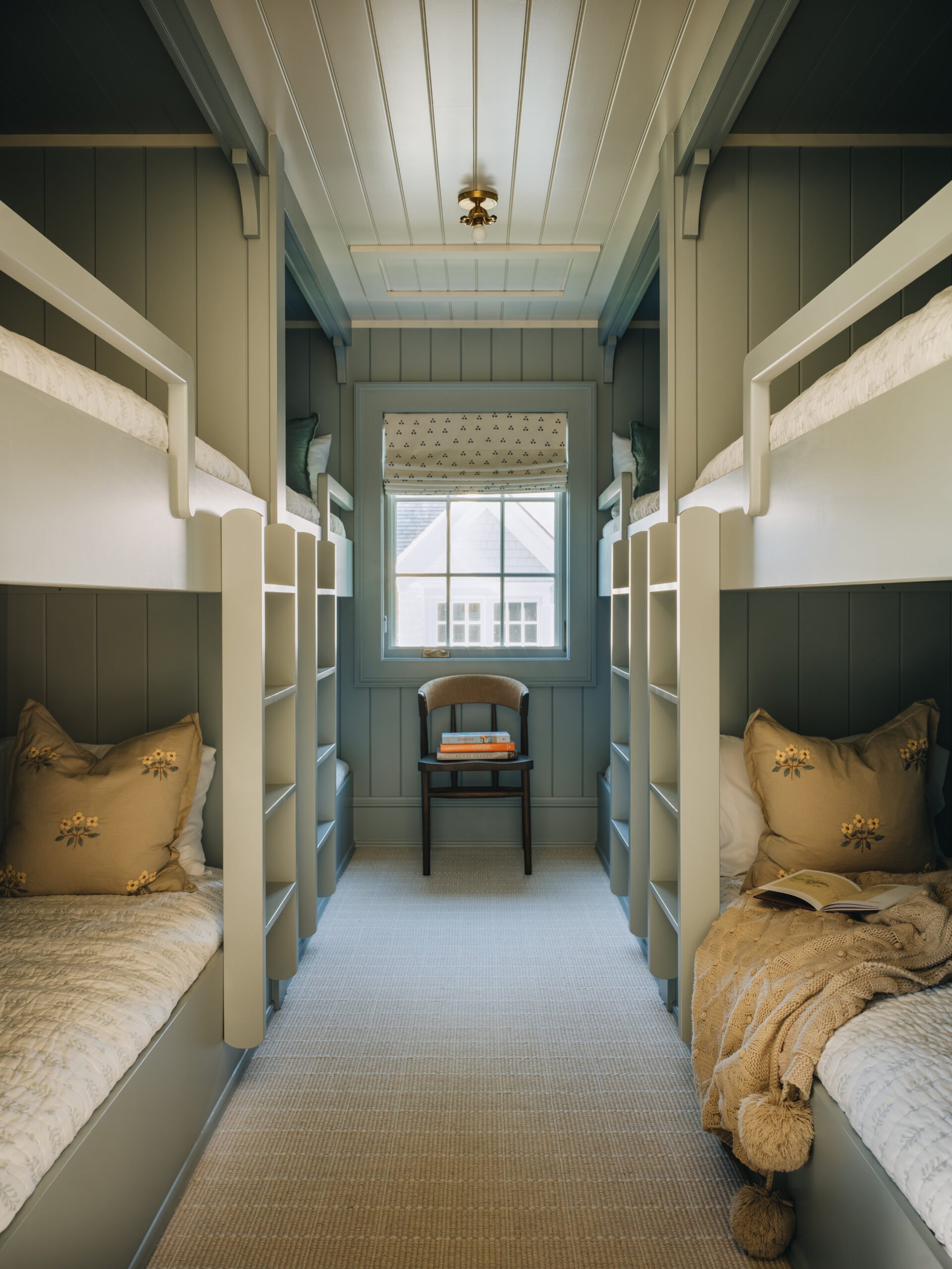 Custom bunk room with built-in beds and vertical shiplap walls in Glen Lake cottage