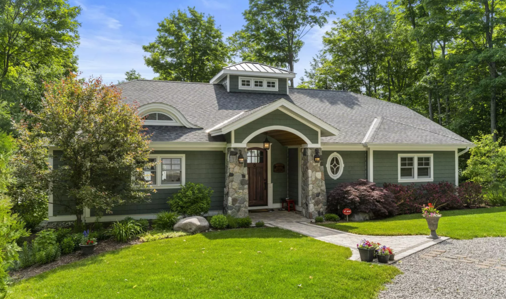 Craftsman-style cottage exterior with stone entry and landscaped front yard